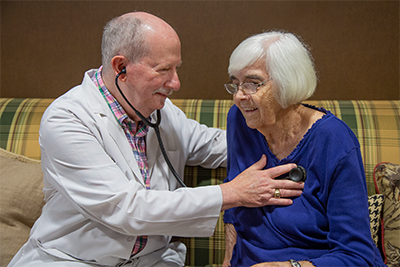 GA Med Group associate holding stethoscope to patient's chest